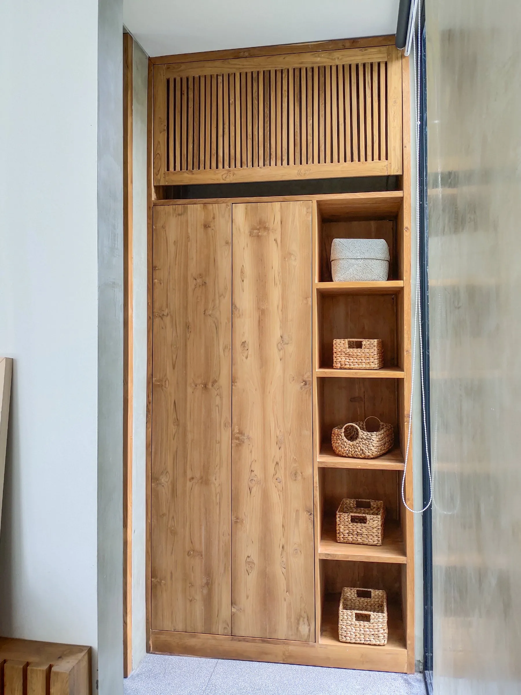 Full-height teak wardrobe with open shelving, fitted between walls.
