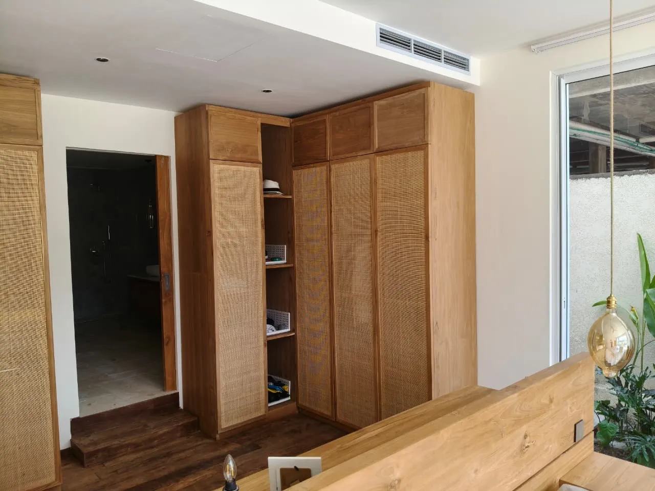Bedroom wardrobe with rattan door panels.