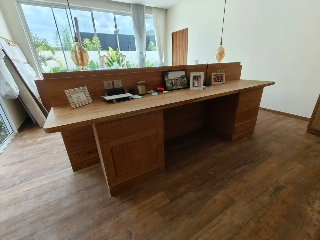 Long teak desk with a raised back panel.
