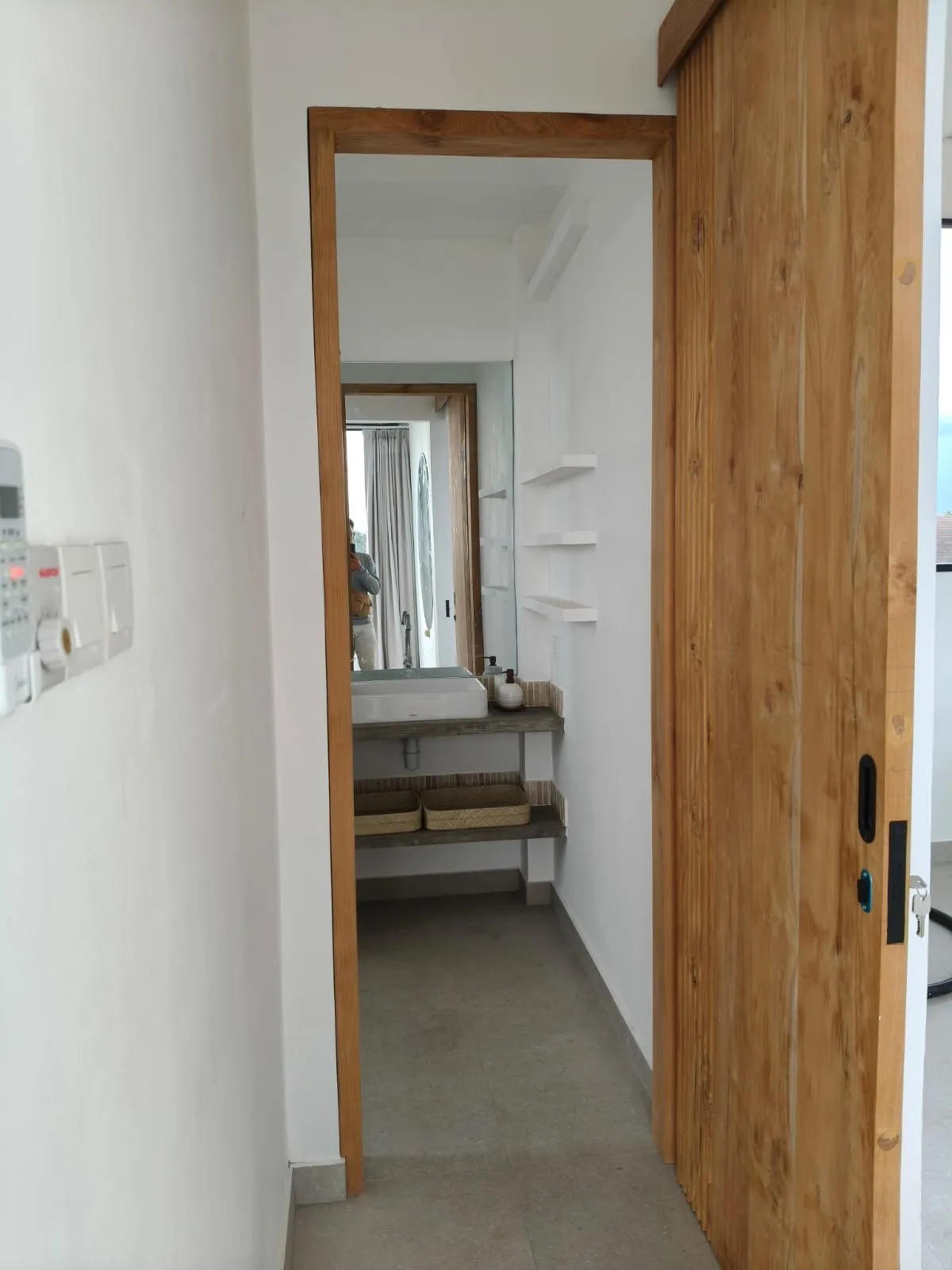 Teak door frame opening onto a bathroom.
