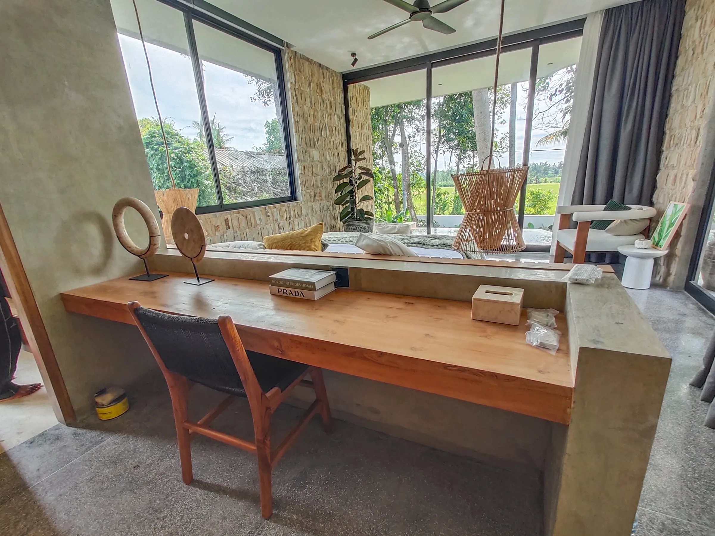 Long teak desk along a window.