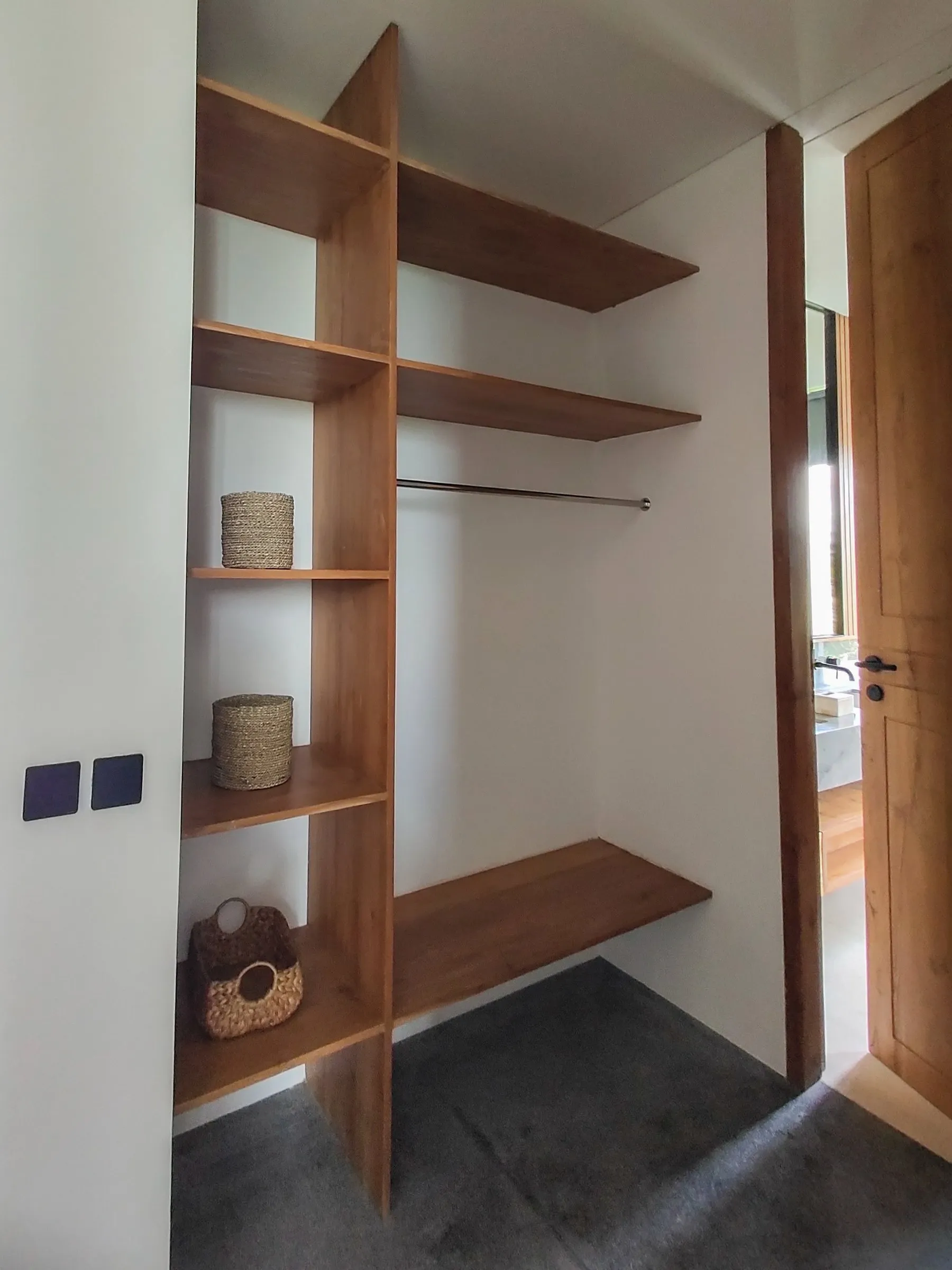 Open teak wardrobe with shelves and hanging space.