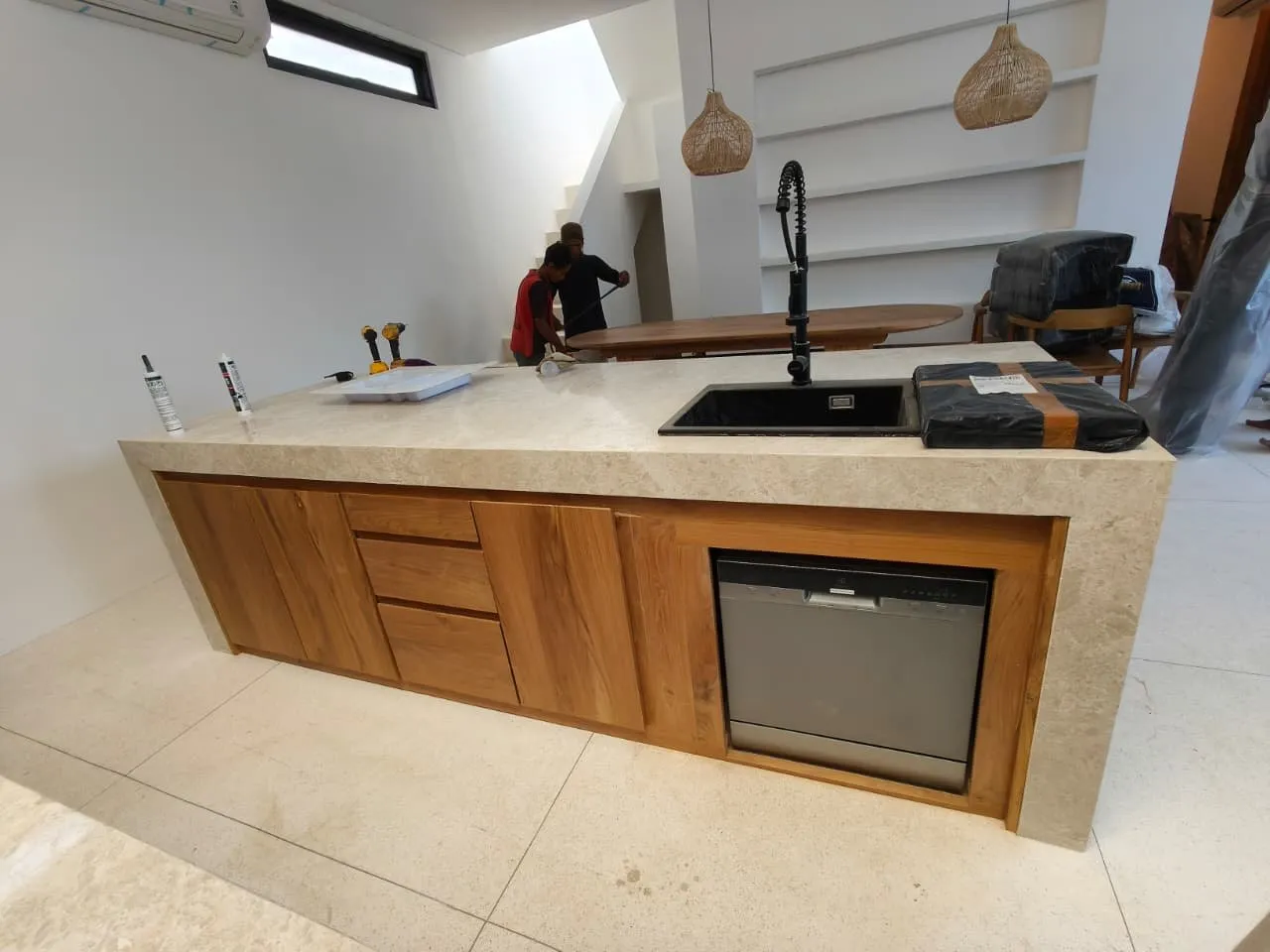 Teak kitchen base units with a stone countertop.
