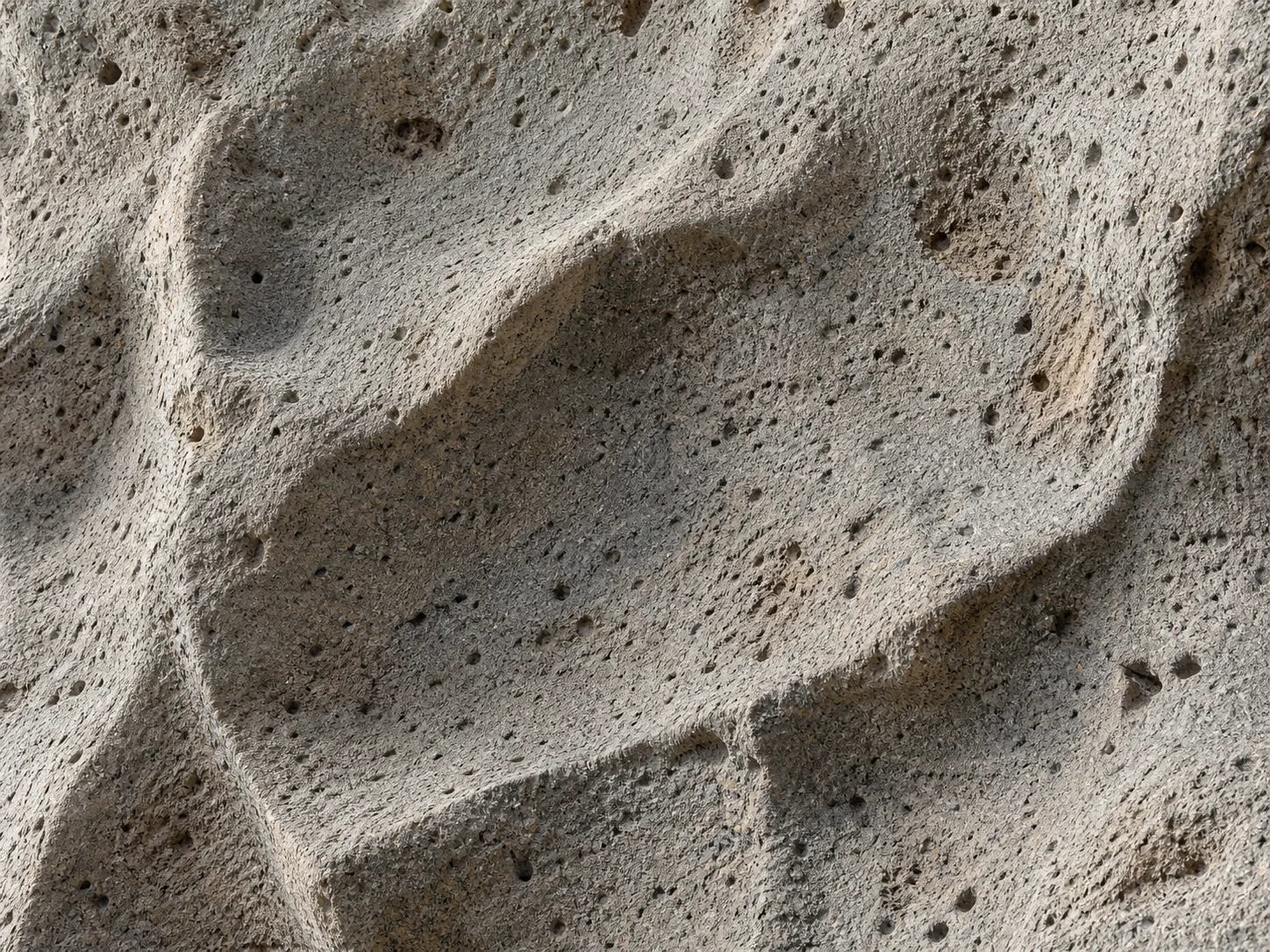 Hand-carved Paras volcanic stone surface showing chisel texture and grey-beige tone
