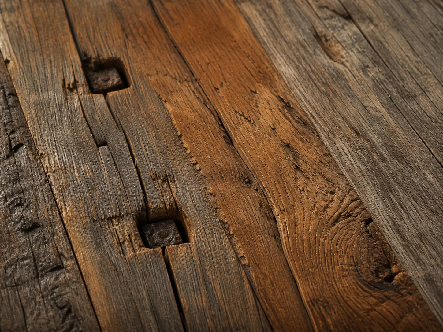 Reclaimed teak surface from Indonesian colonial structure showing age patina and bolt marks