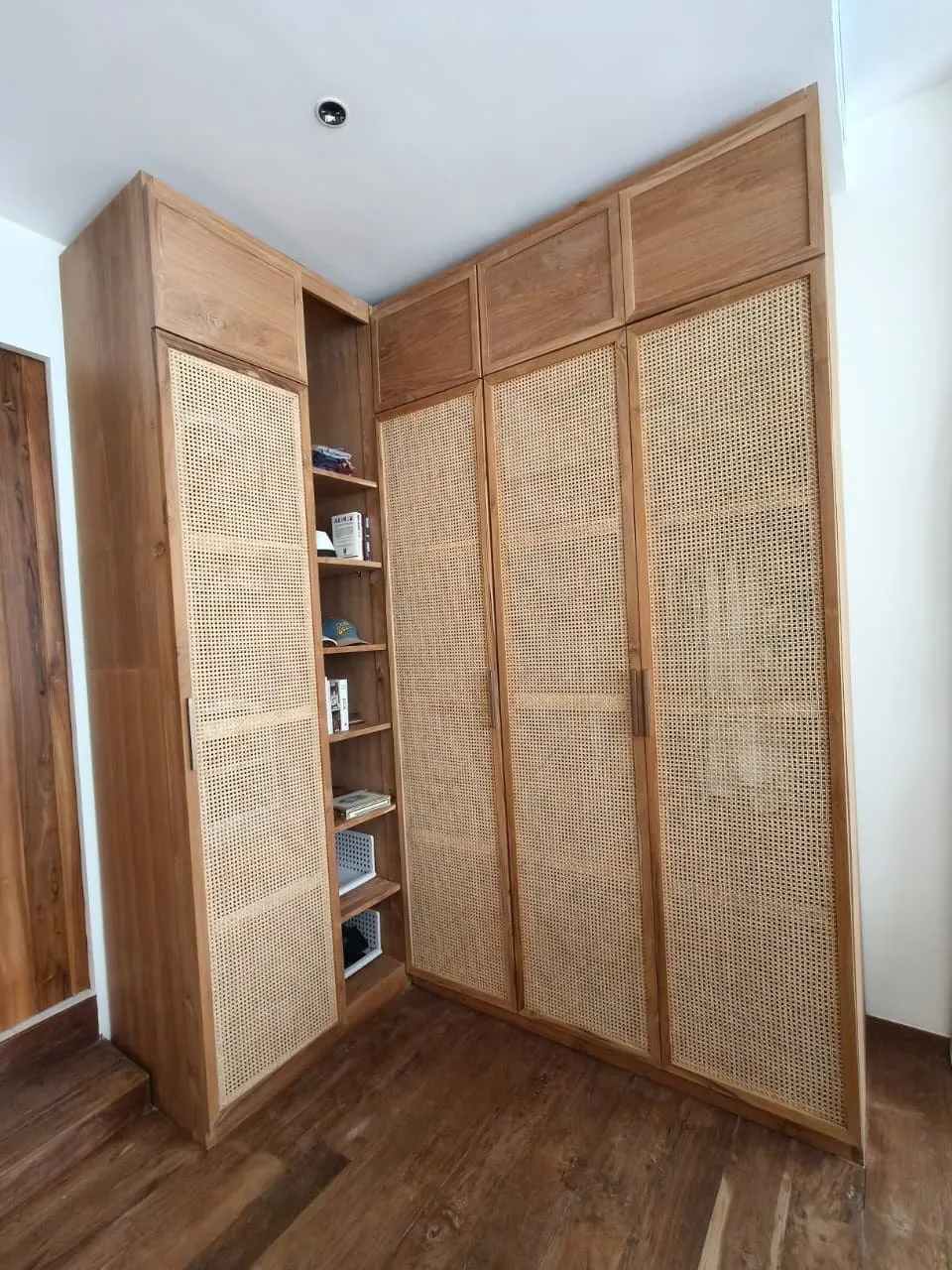 Teak wardrobe with rattan panels and open shelving.