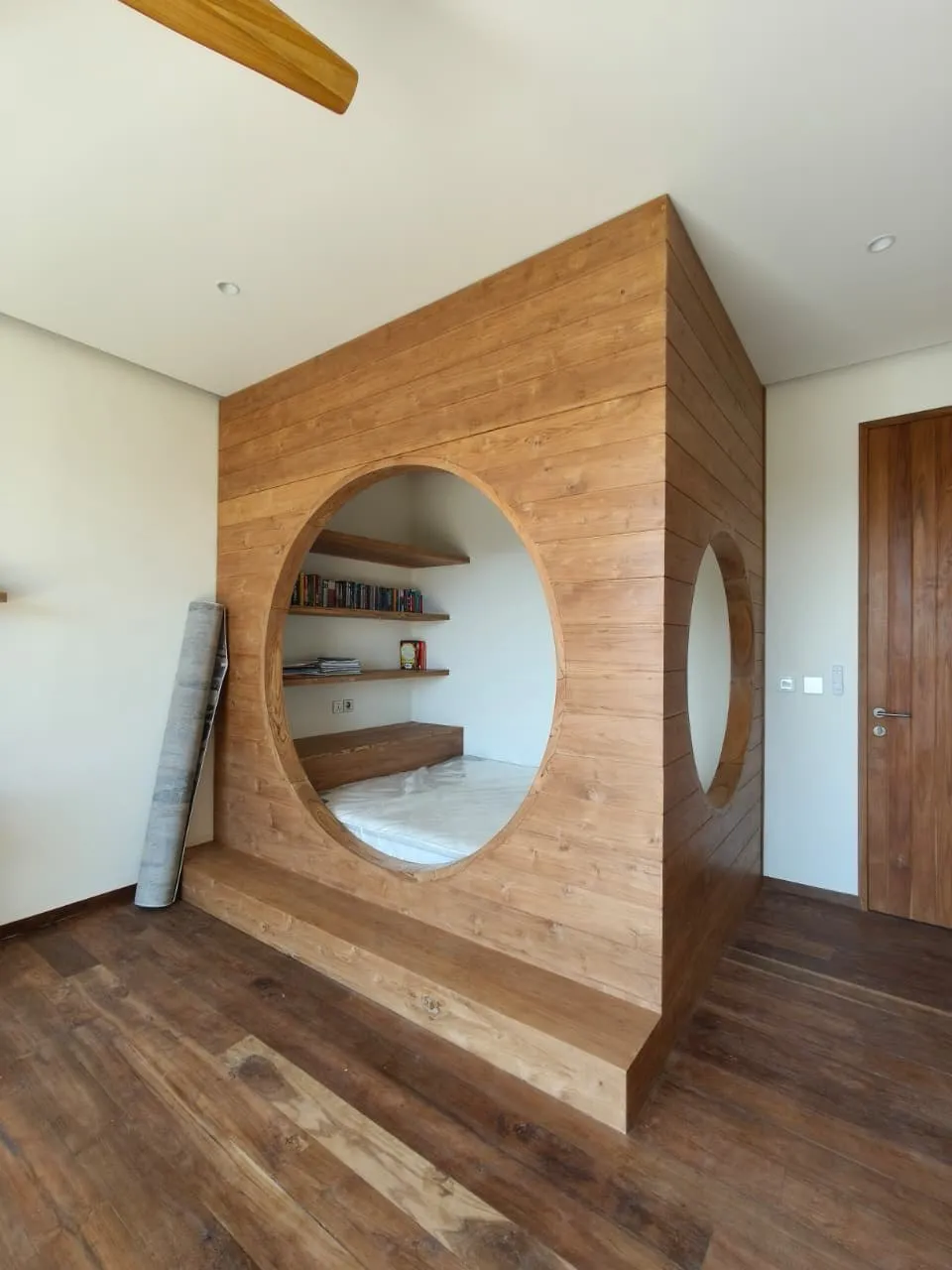 Teak room divider with a round opening.